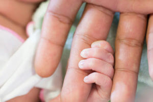 newborn holding parent's finger