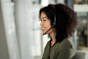 Cropped shot of an attractive young businesswoman wearing a headset and sitting alone in her office